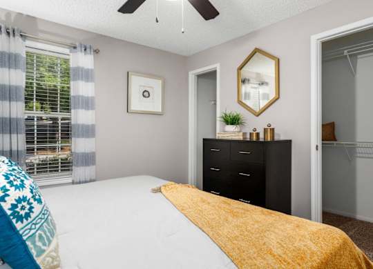 Carpeted bedroom with ceiling fan, and large closets at Summerchase at Riverchase in Hoover, Alabama