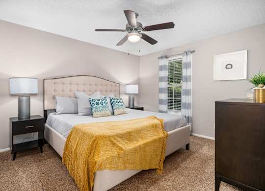 Carpeted bedroom with ceiling fan, and window at Summerchase at Riverchase in Hoover, Alabama