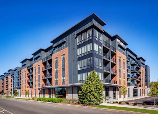 A modern multi-story residential apartment building with balconies at Wesley Place Apartments in Indianapolis, IN