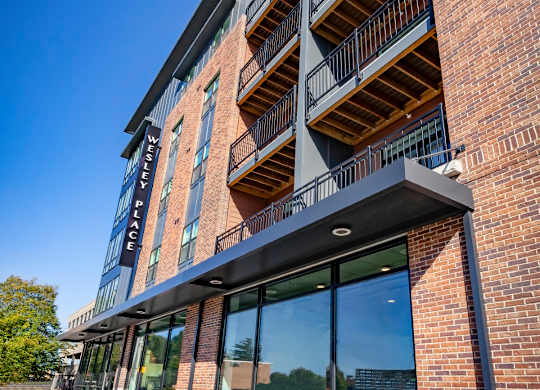 A modern apartment building with balconies at Wesley Place Apartments in Indianapolis, IN