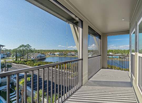 A balcony with a view of a body of water and houses.