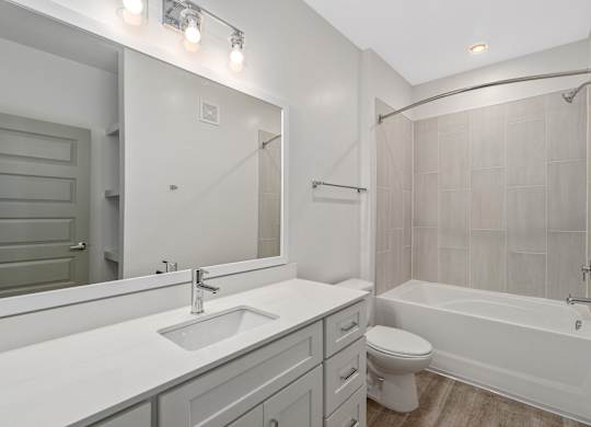 A white bathroom with a sink, toilet, and bathtub.