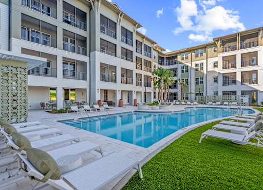 A large white building with a pool in front.