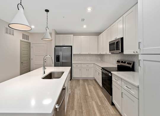 A modern kitchen with white cabinets and appliances.