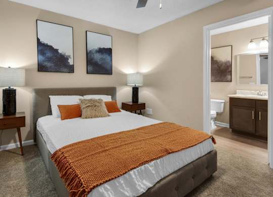 A bedroom with a connected bathroom and a ceiling fan at Crystal Lake in Pensacola, Florida.