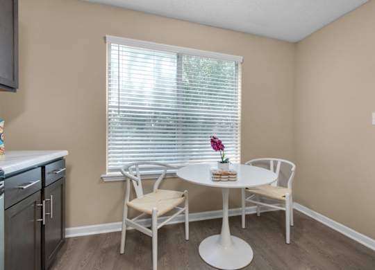 A dining area with wood flooring and a large window at Crystal Lake in Pensacola, Florida.