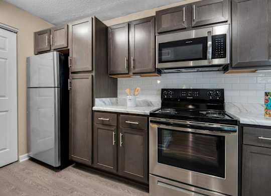 A kitchen with a black stove top oven and stainless-steel appliances at Crystal Lake in Pensacola, Florida.