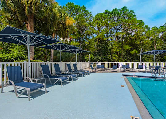 Sun loungers and umbrellas that surround the outdoor pool at Crystal Lake in Pensacola, Florida.