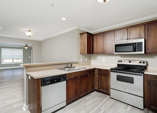 a well lit kitchen with lots of cabinets and countertop workspace at The Oakley at Deerfield Apartments in Florence, AL