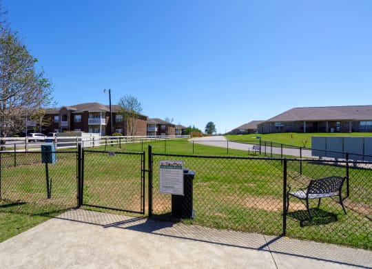 fenced dog park with benches at The Oakley at Deerfield Apartments in Florence, AL