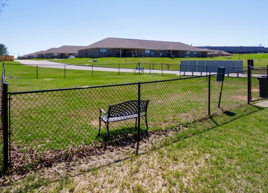 leash-free pet park with sitting area at The Oakley at Deerfield Apartments in Florence, AL