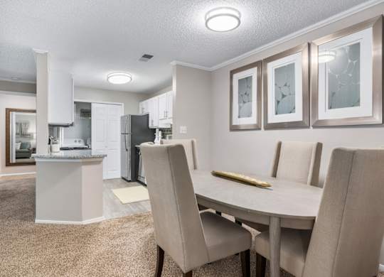 Carpeted dining room with overhead lighting adjacent to kitchen at Summerchase at Riverchase in Hoover, Alabama