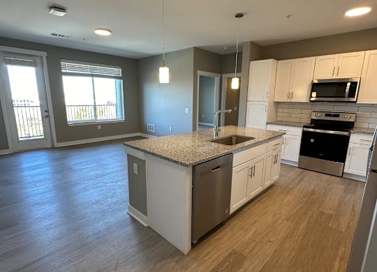 A kitchen with a large island and stainless-steel appliances at The Fitzroy Apartments in Birmingham, AL