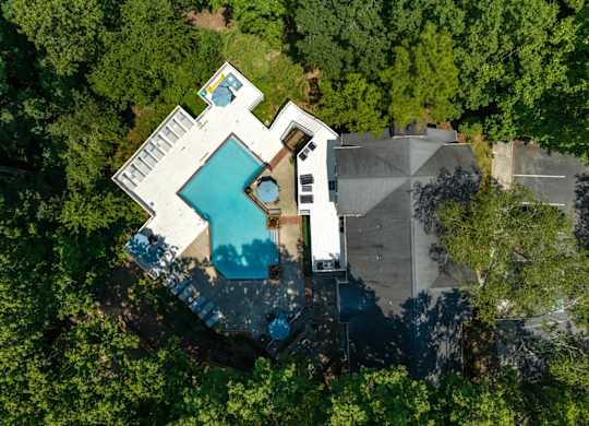 An aerial view of the pool and pool deck surrounded by trees at Summerchase at Riverchase in Hoover, Alabama