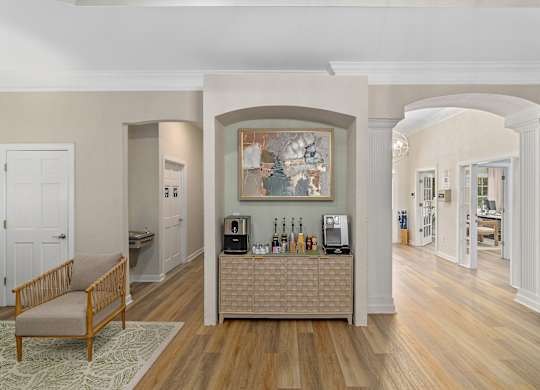 A living room with a wooden floor and a large painting on the wall.