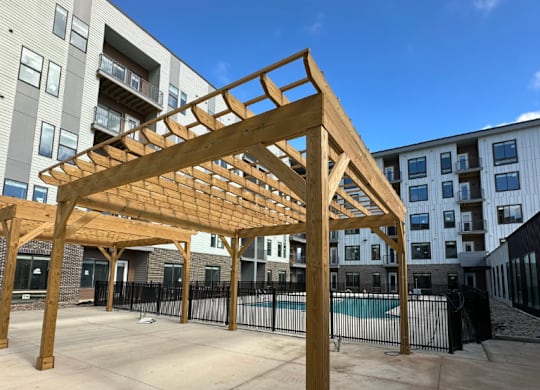 A wooden grilling pergola is adjacent to the swimming pool in the courtyard of the Fitzroy apartment complex in Birmingham, Alabama.
