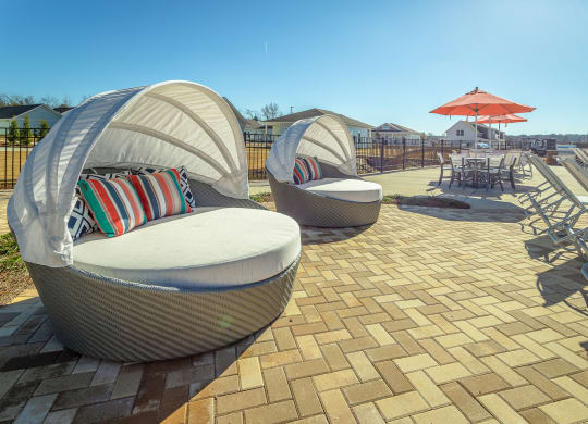 a patio with chairs and umbrellas at Anthem Apartments and Cottages in Huntsville, Alabama