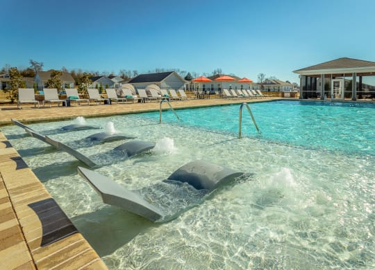 a resort style pool with chaise lounge chairs and a screened gazebo at Anthem Apartments and Cottages in Huntsville, Alabama