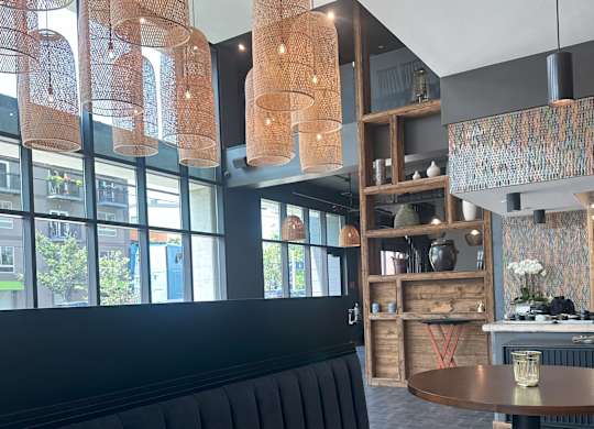 a dining room with a wooden table and black booths
