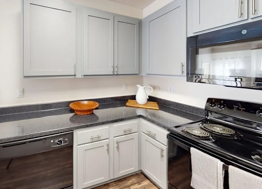 A kitchen with white cabinets and a black stove top.
