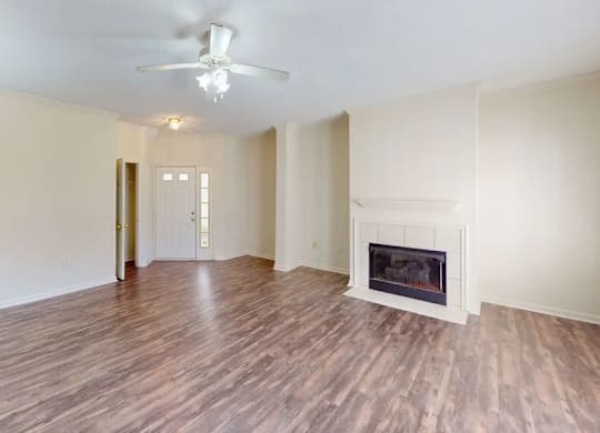 A room with a fireplace and wood flooring.
