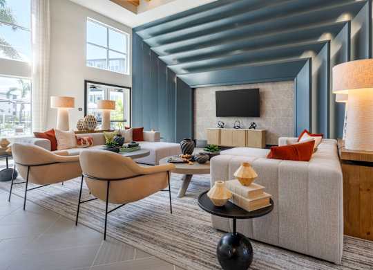 A modern living room with a grey sofa, a wooden coffee table, and a TV mounted on the wall.