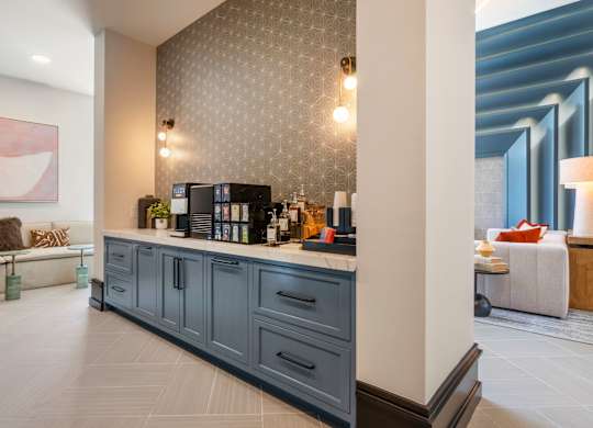 A modern kitchen with a grey cabinetry and a white countertop.