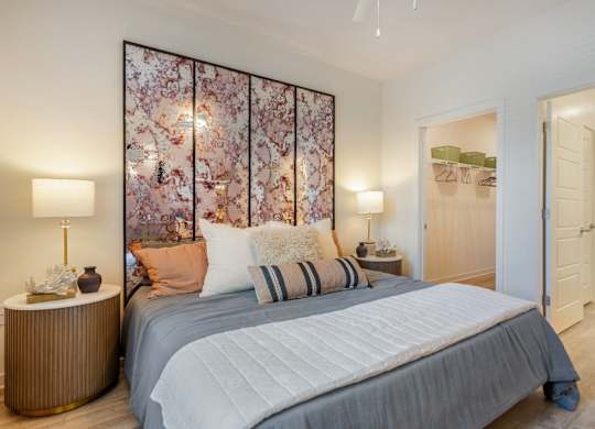 A bedroom with a large bed and a floral wallpaper.