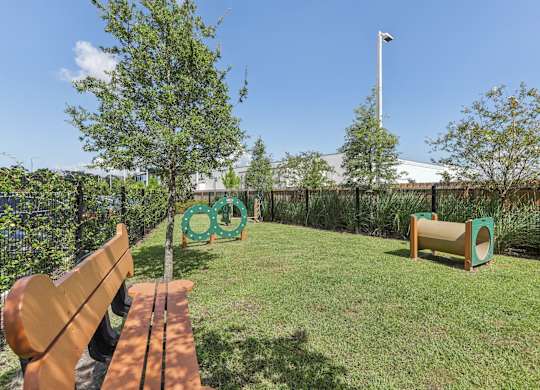 a yard with a bench and trees and a fence