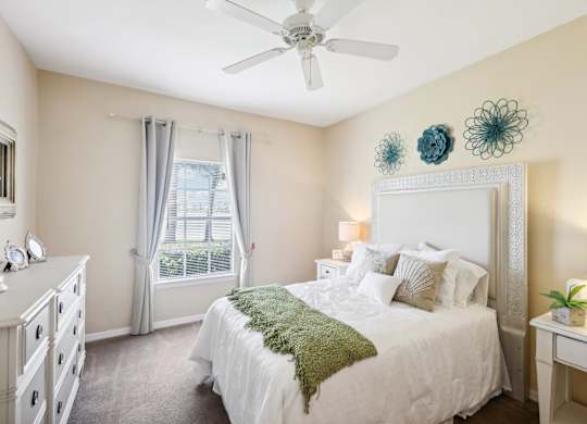 a bedroom with a bed and a ceiling fan
