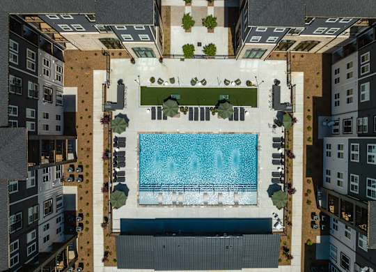 A swimming pool surrounded by buildings and trees.