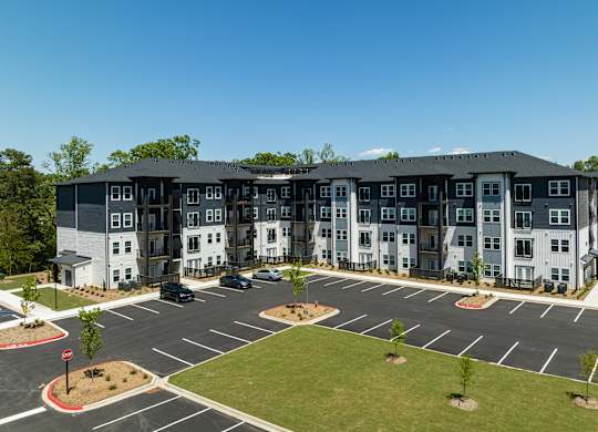 A large, modern building with a parking lot in front.