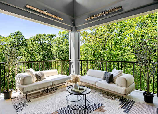 A patio with a white couch and a coffee table.