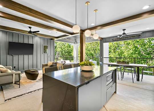 A modern kitchen with a large island and a television mounted on the wall.