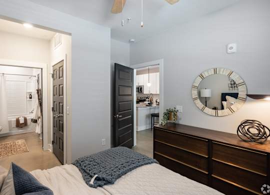 A bedroom with a bed, dresser, and mirror.