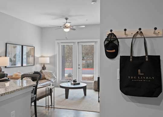 A black bag hangs on a hook in a room with a ceiling fan.