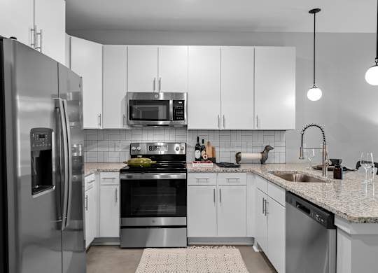 A modern kitchen with stainless steel appliances and white cabinets.