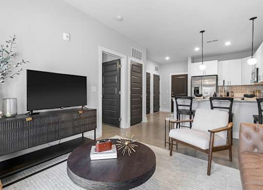 A modern living room with a black entertainment center and a brown leather couch.