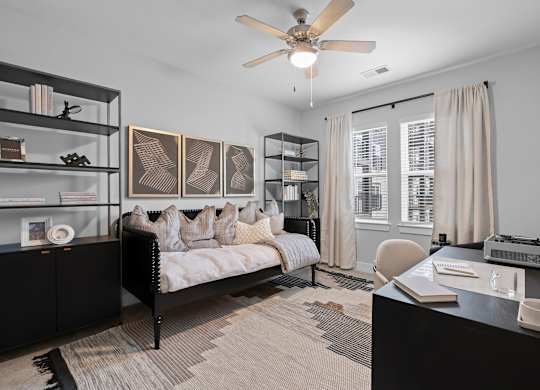 A bedroom with a bed, desk, and shelves.