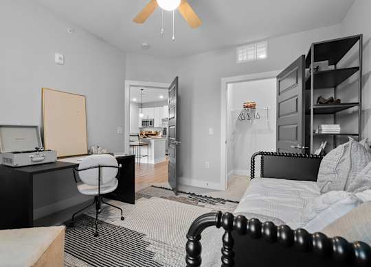 A bedroom with a bed, desk, and chair.