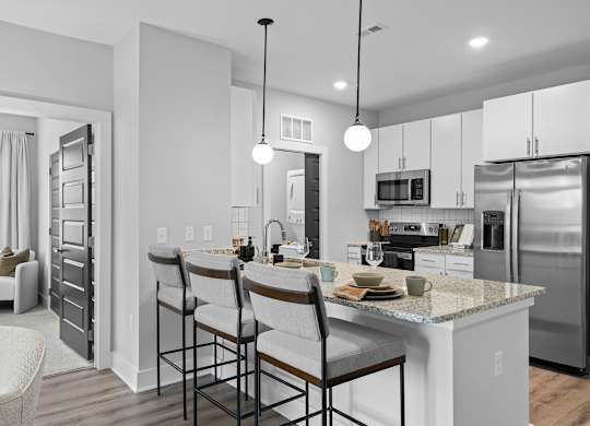 A modern kitchen with a bar area and stainless steel appliances.