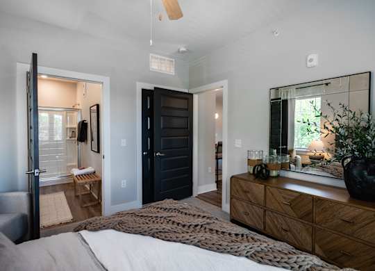 A bedroom with a bed, dresser, and mirror.