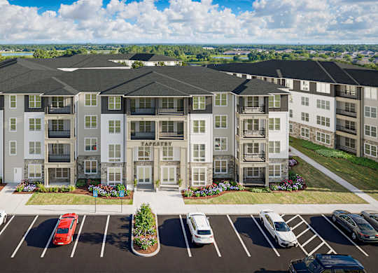 A large apartment complex with a parking lot in front.