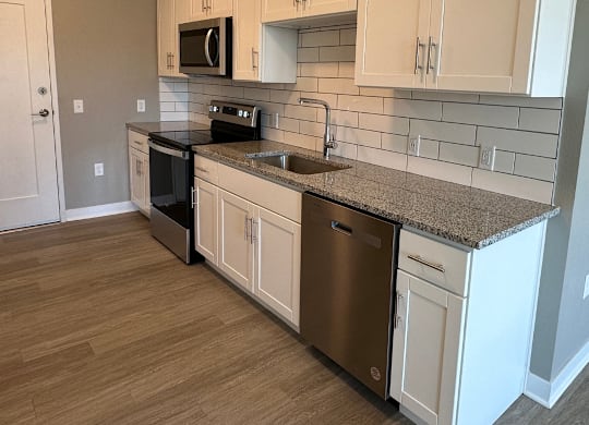 kitchen with subway tile backsplash and wood-style flooring  at The Fitzroy Apartments in Birmingham, AL