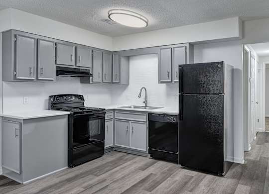 A kitchen with black appliances and white cabinets.
