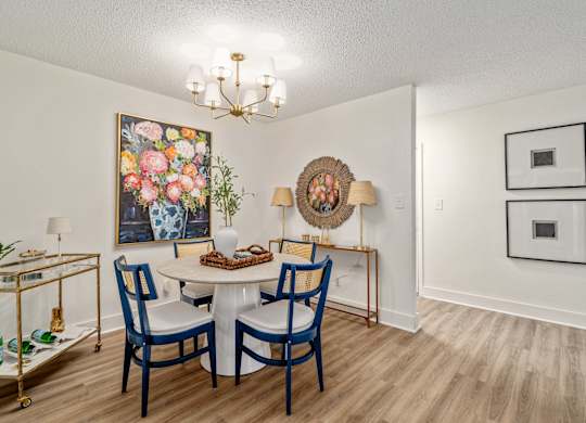 A dining room with a white table and blue chairs.