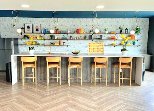 a kitchen with a long counter and a bunch of stools in front of it