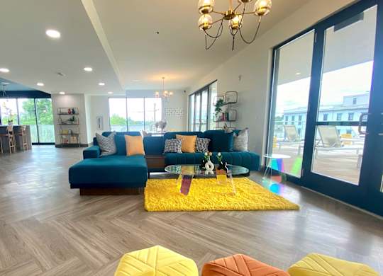 a living room with a blue couch and yellow rug