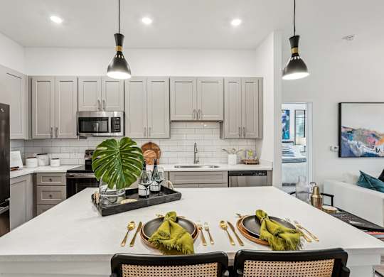 A modern kitchen with island and stainless steel appliances at Tapestry University Park apartments in Sarasota, FL