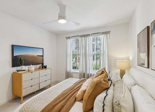 A bedroom with a large bed and a painting on the wall.